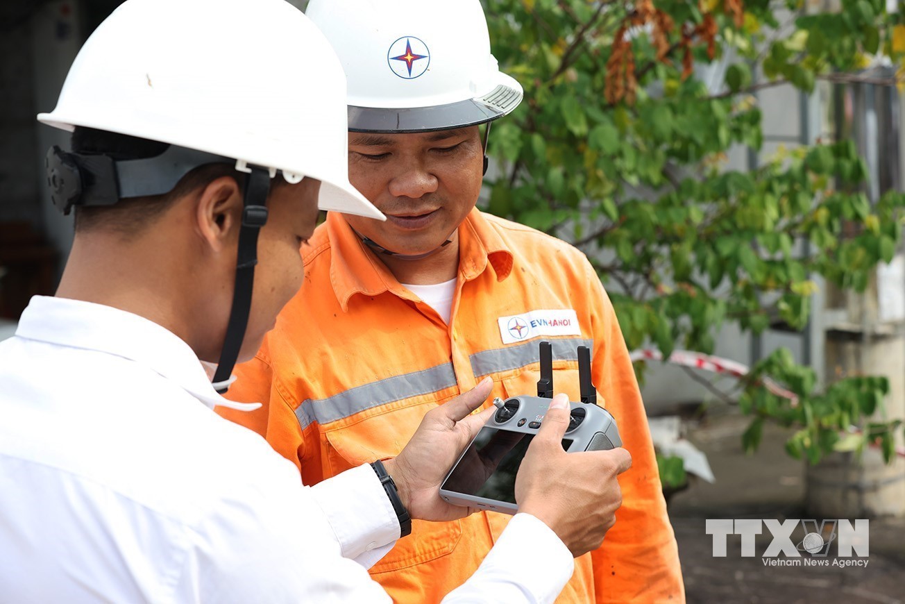 Sử dụng thiết bị bay không người lái (flycam), giúp phát hiện các khiếm khuyết trên lưới điện mà không cần trèo cao hay cắt điện trên đường dây 110kV, xã Hạ Bằng. (Ảnh: Vũ Sinh/TTXVN)